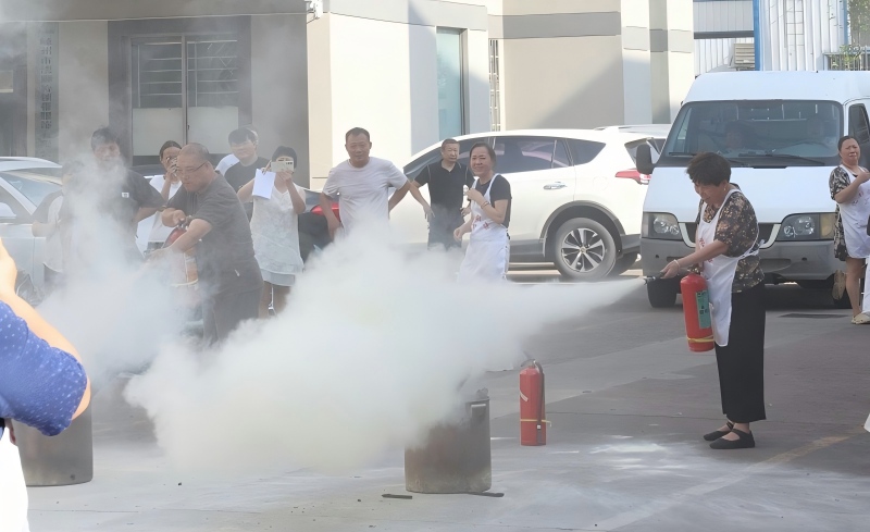 YILI employee practicing proper fire extinguisher technique during safety training